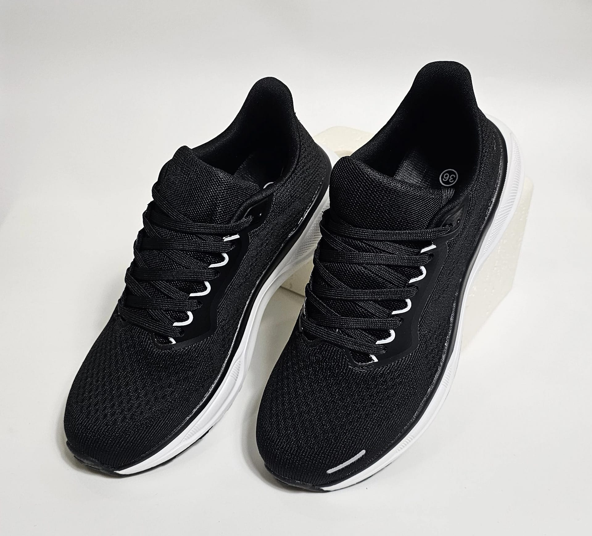 حذاء رياضي أسود بتفاصيل بيضاء لمظهر عصري ومريح. حذاء رياضي أسود بتفاصيل بيضاء لمظهر عصري ومريح.